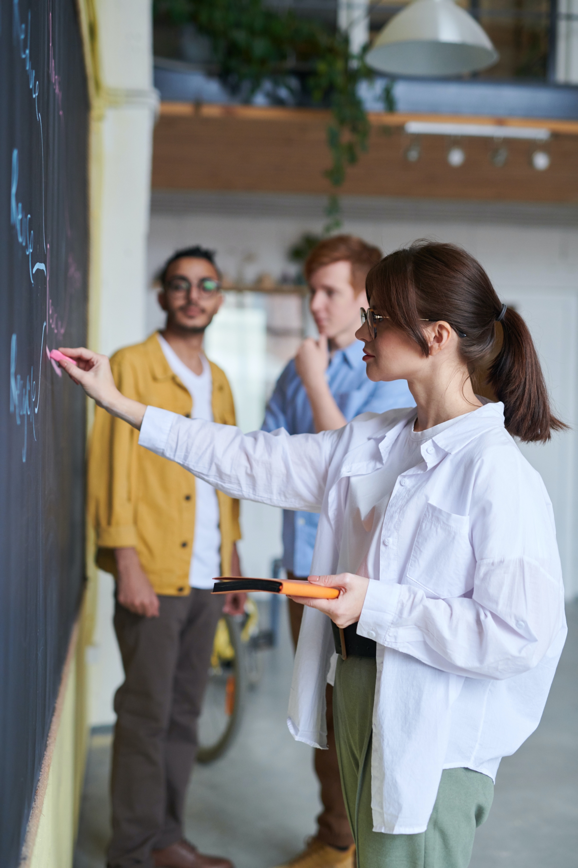 Young woman writing on a chalk board